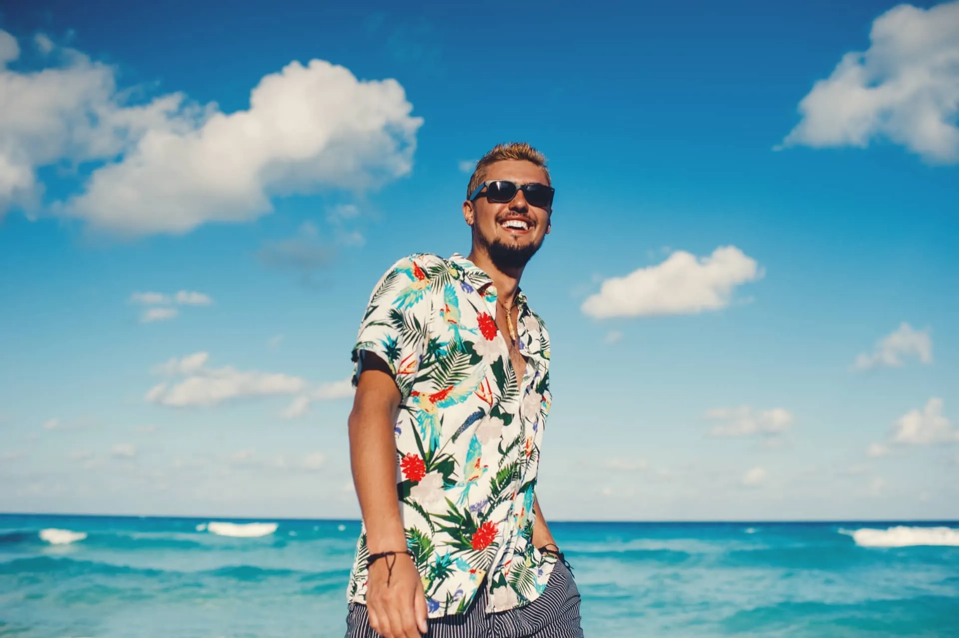 ハワイの海で男性がアロハシャツを着て楽しんでいる様子